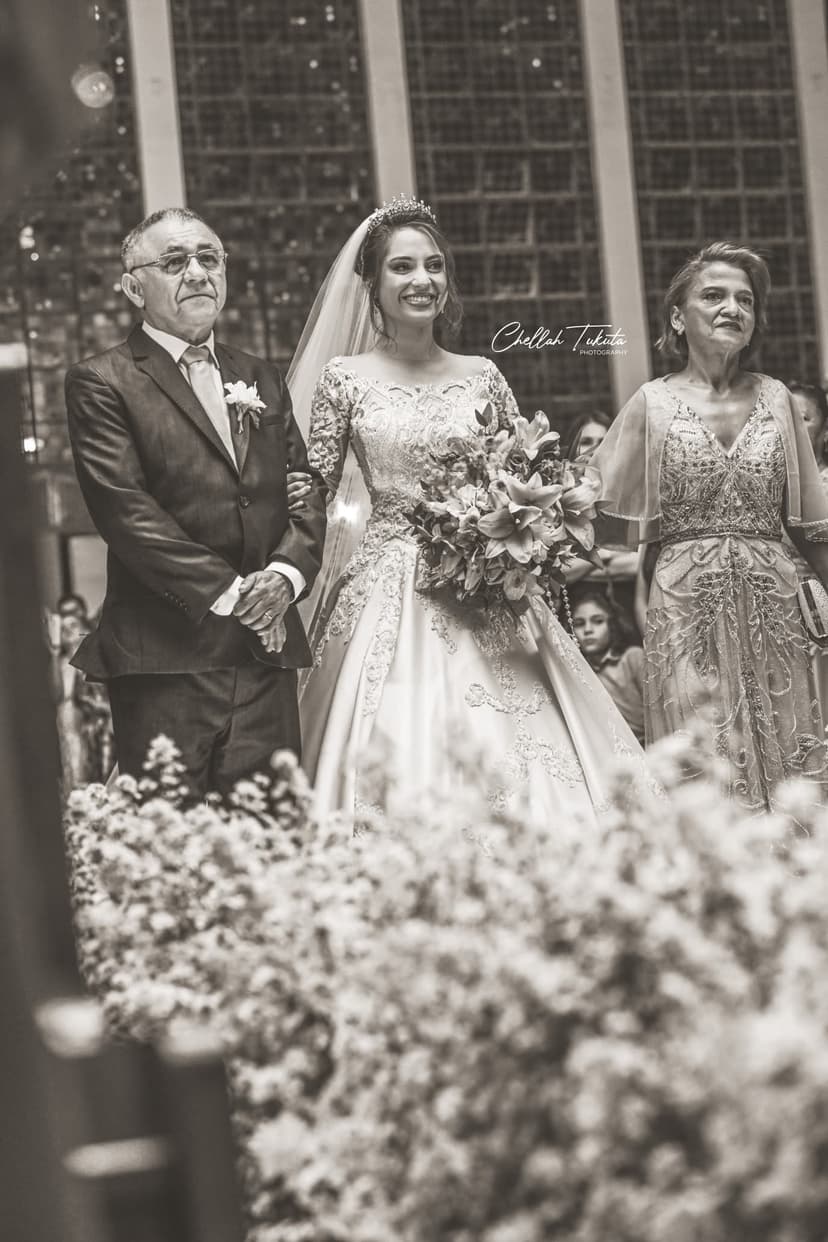 Black and white bridal processional - bride walking with both parents holding bouquet