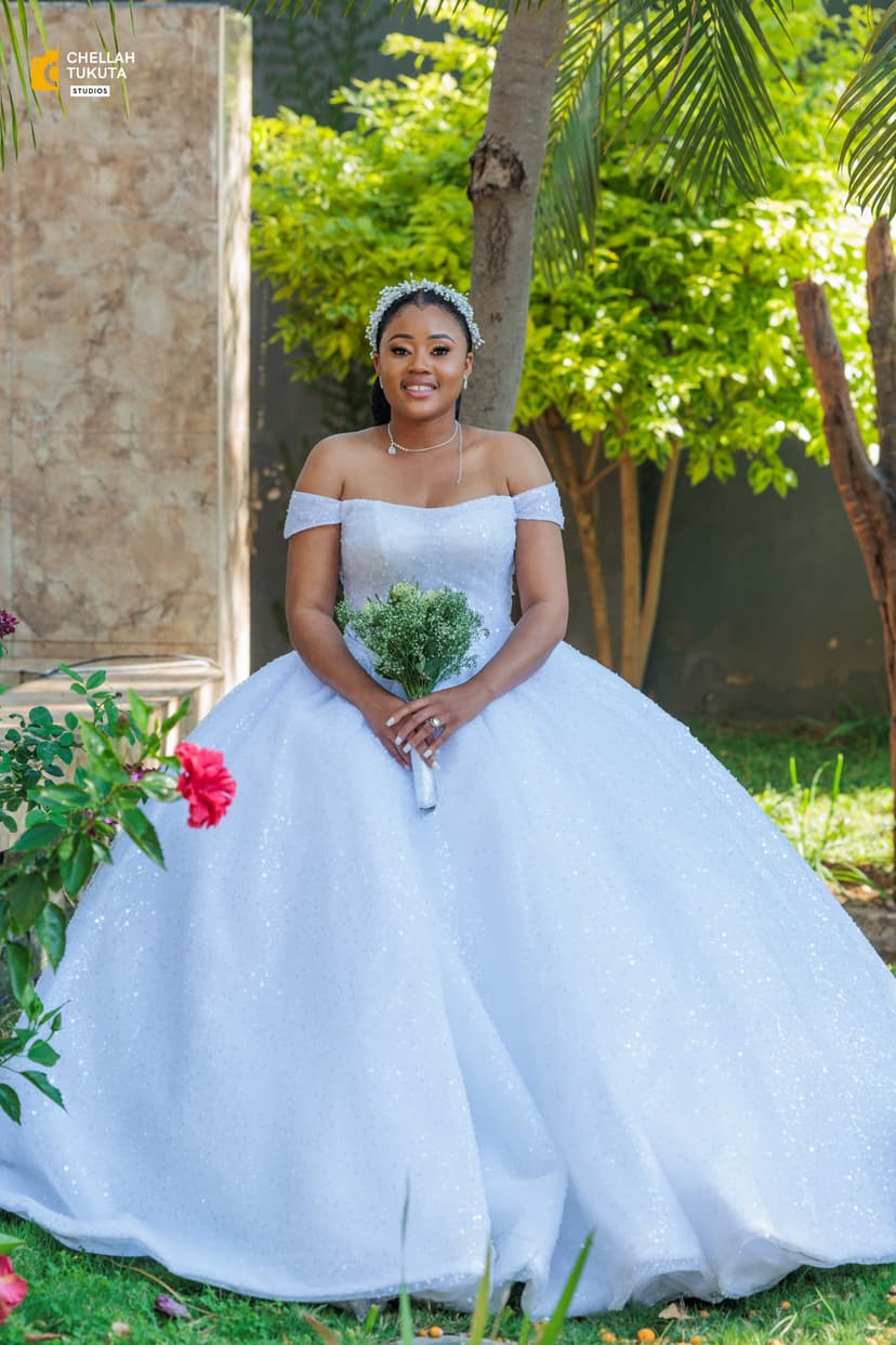 Seated bridal portrait with bouquet in garden