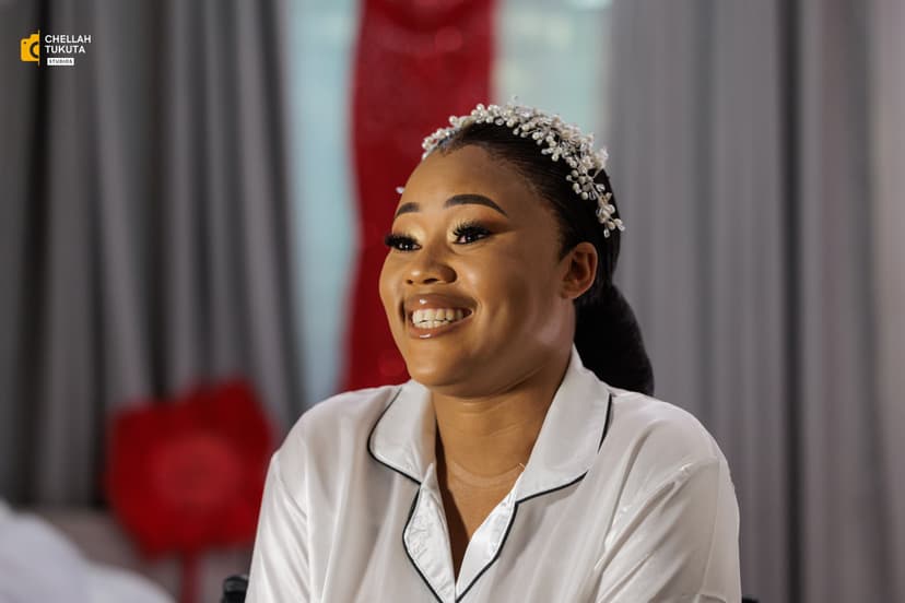 Bridal preparation - bride in white robe with tiara smiling