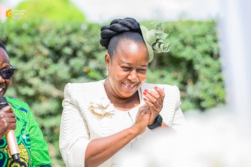 Elegant wedding guest in white outfit with green fascinator applauding