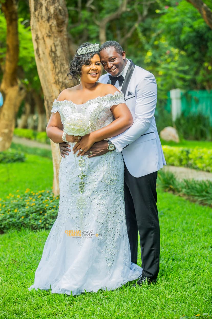 Romantic couple embrace - bride in sparkly gown with tiara, groom in gray suit
