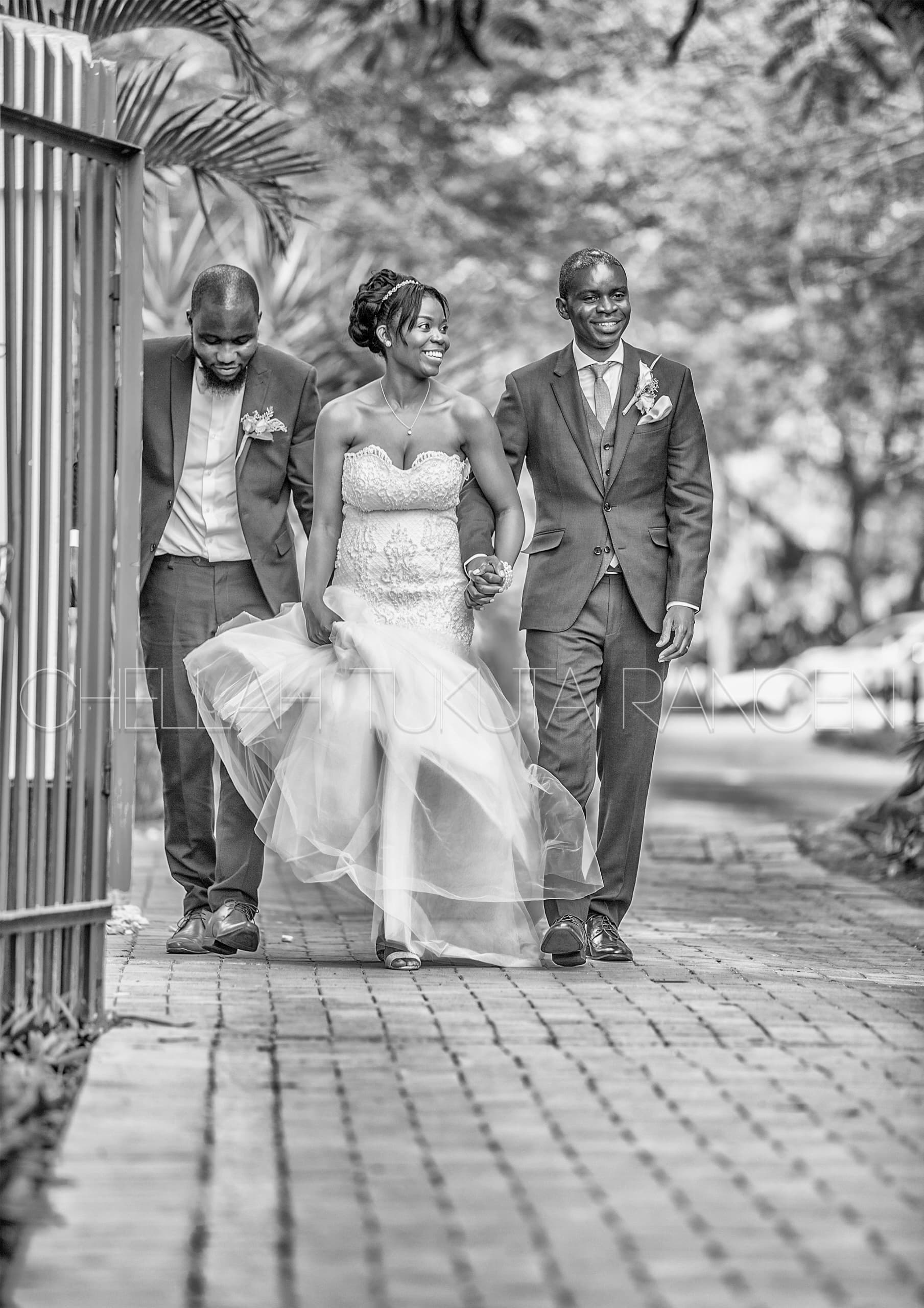 Artistic black and white - bride in beaded gown walking with groom and father